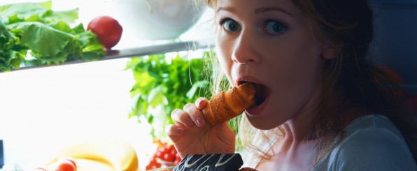 冷蔵庫の中のものを食べる女性