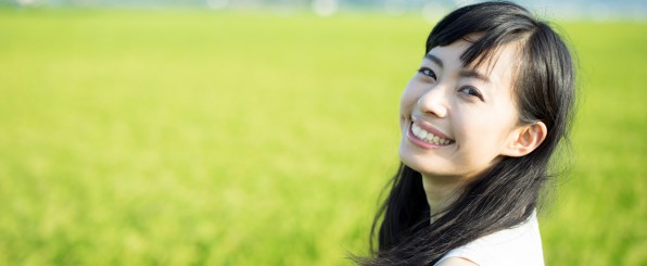 水田にて笑顔で振り返る女性