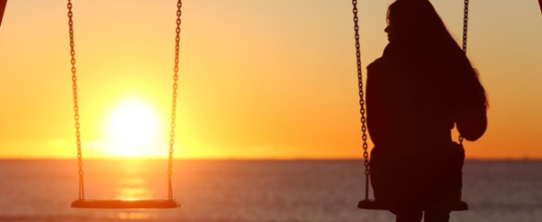 夕暮れのブランコにのった女性